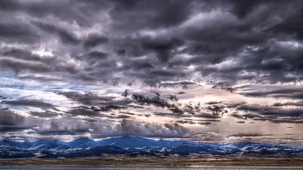 click to free download the wallpaper--Depressing Scene of Nature - The Sky is Dark with Thick Clouds, Mountains Are Tall As to Reach the Sky