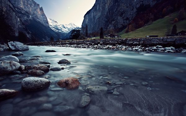 click to free download the wallpaper---Flowing Slowly Yet Persistently, Tall Hills Alongside, Clean and Clear Stones, a Spectacular Scene - HD Natural Scenery Wallpaper