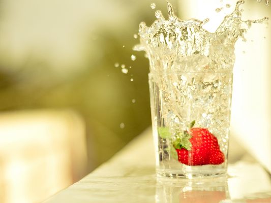 click to free download the wallpaper--Free Fruits Wallpaper, Glass Of Water, Red Strawberry Jumping in